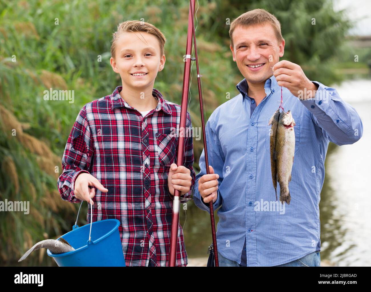 Friendly father with son looking at fish on hook Stock Photo