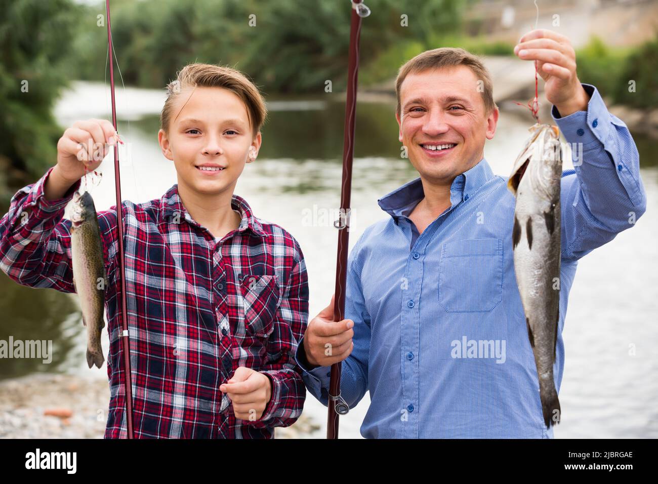 Young father with son looking at fish on hook Stock Photo