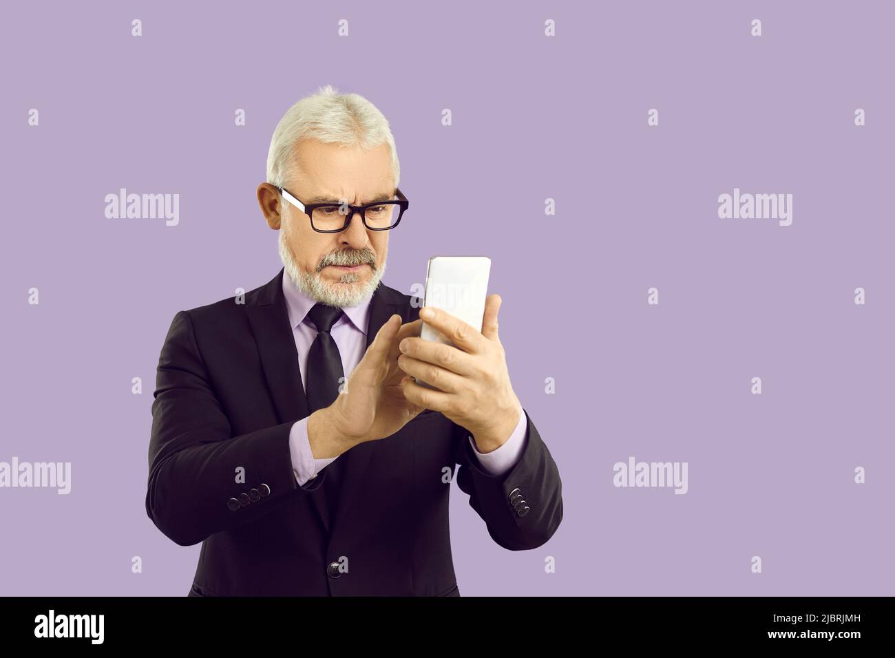 Mature grey-haired businessman using cellphone device Stock Photo