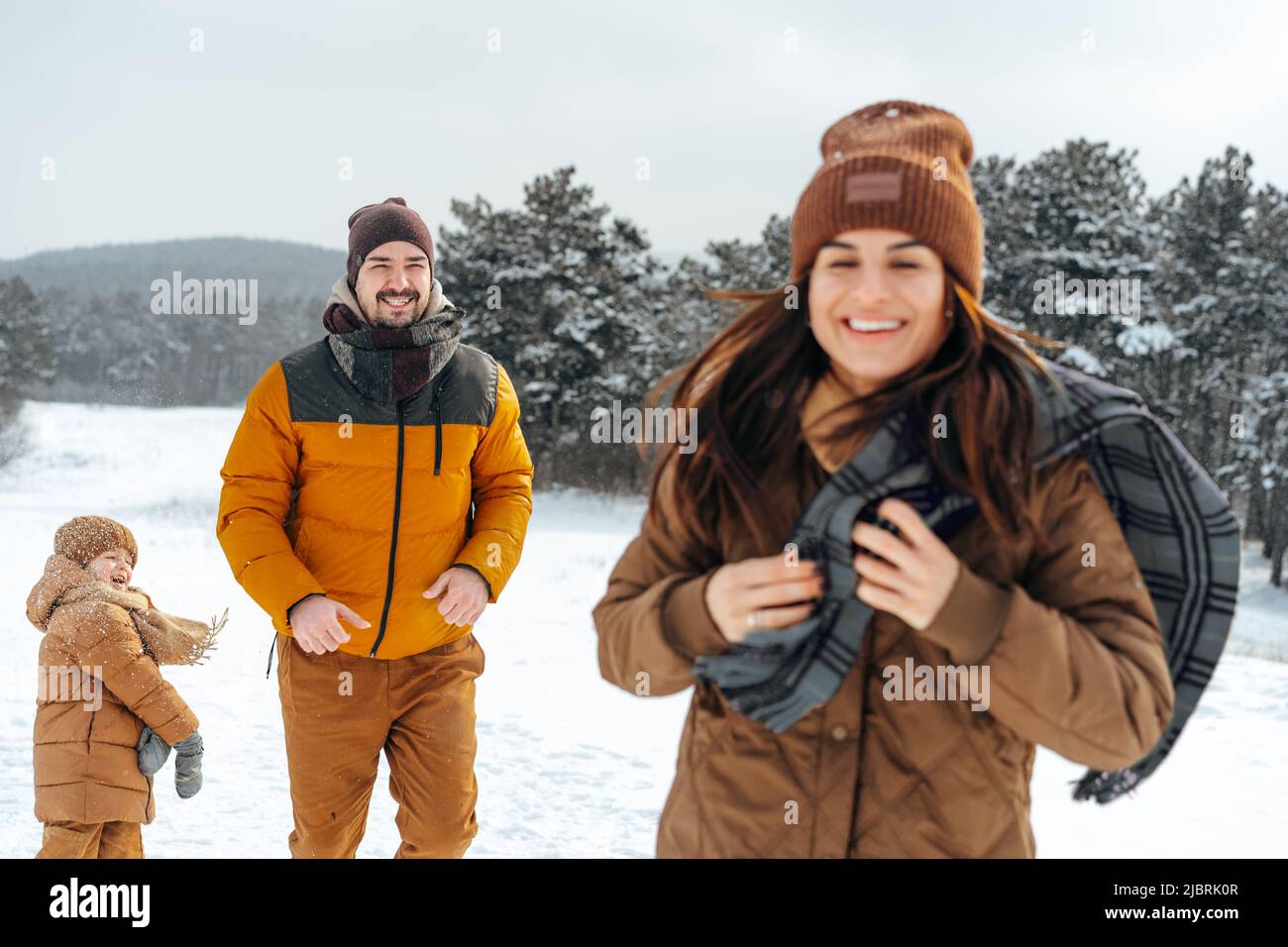 Happy family having a walk in winter outdoors in snow Stock Photo - Alamy