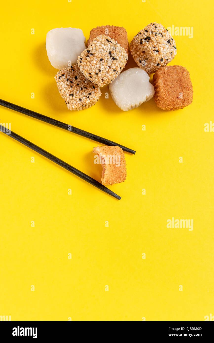 Japanese Mochi dessert sticks on a bright yellow background Stock Photo