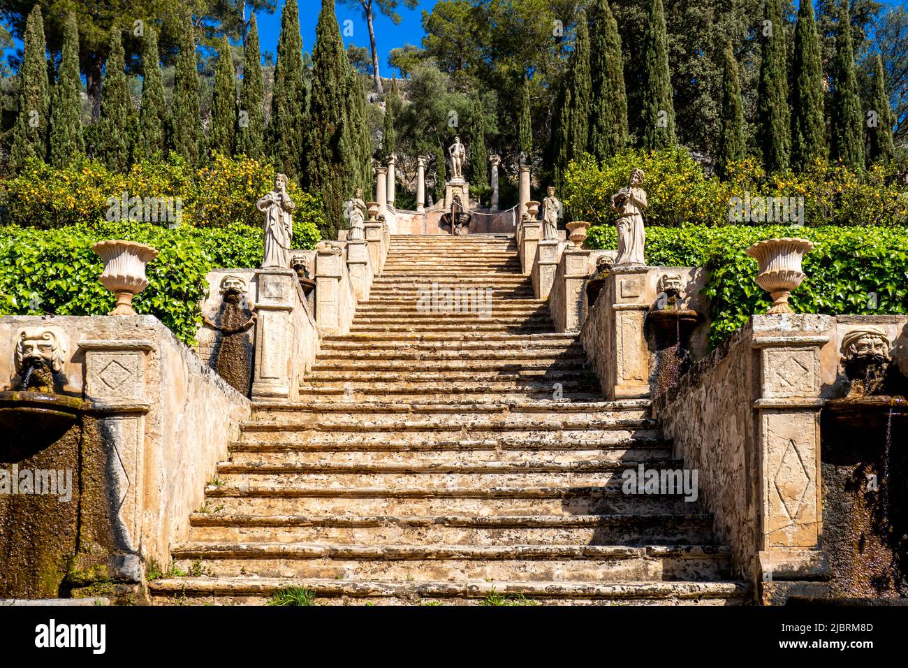 View over an old staircase with ancient sculptures, gargoyles and amphorae called Apollo Staircase up to a stonemade statue of the god Apollo. Stock Photo
