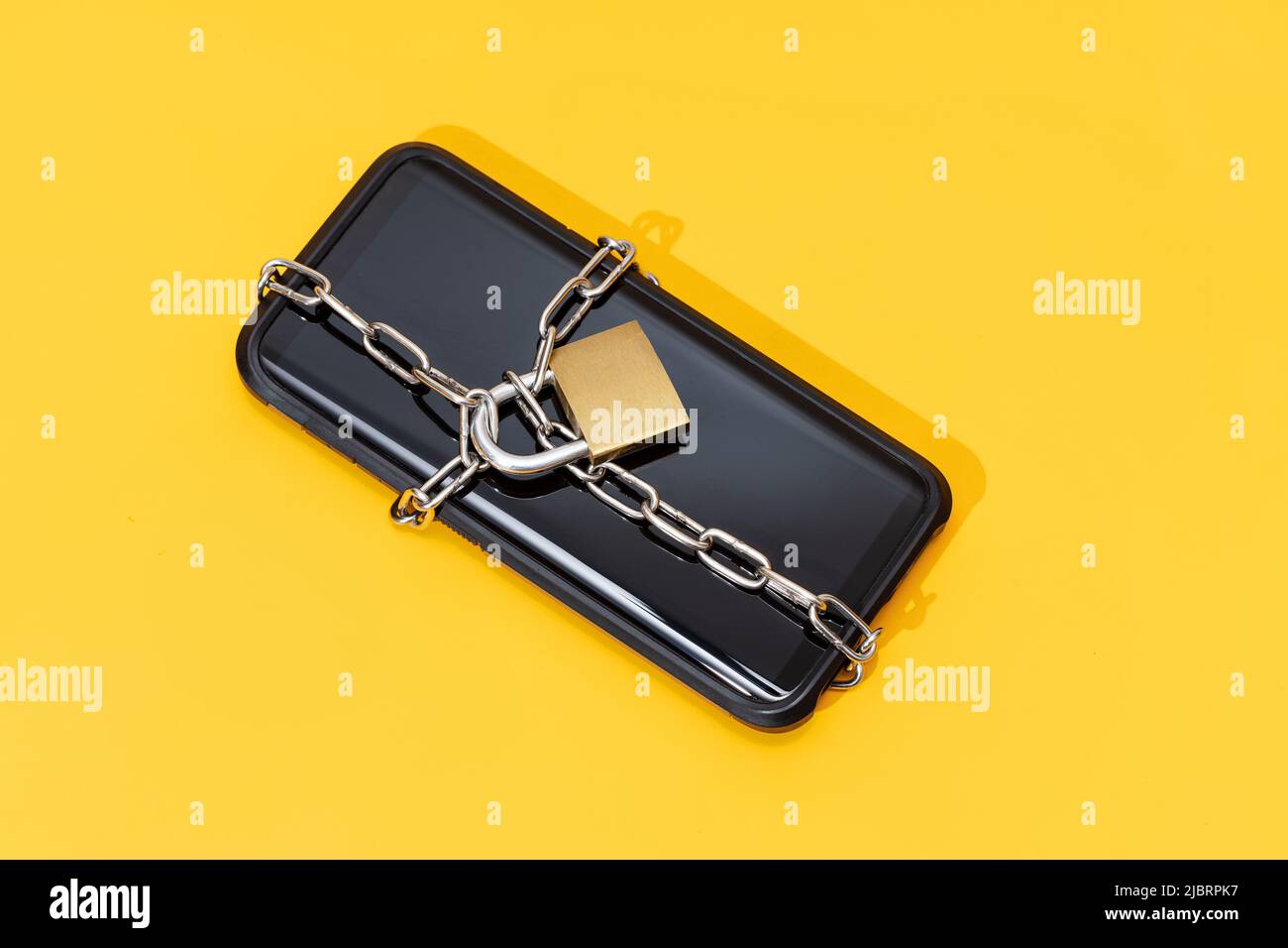 Phone security concept. Smartphone locked with chain and padlock on