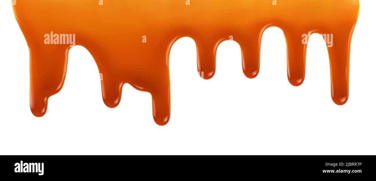 Dripping caramel drops of sweet sauce isolated on white background