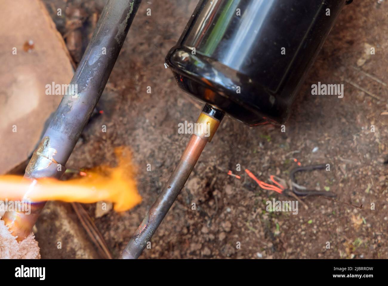 HVAC plumber technician soldering a copper pipe joint for central air