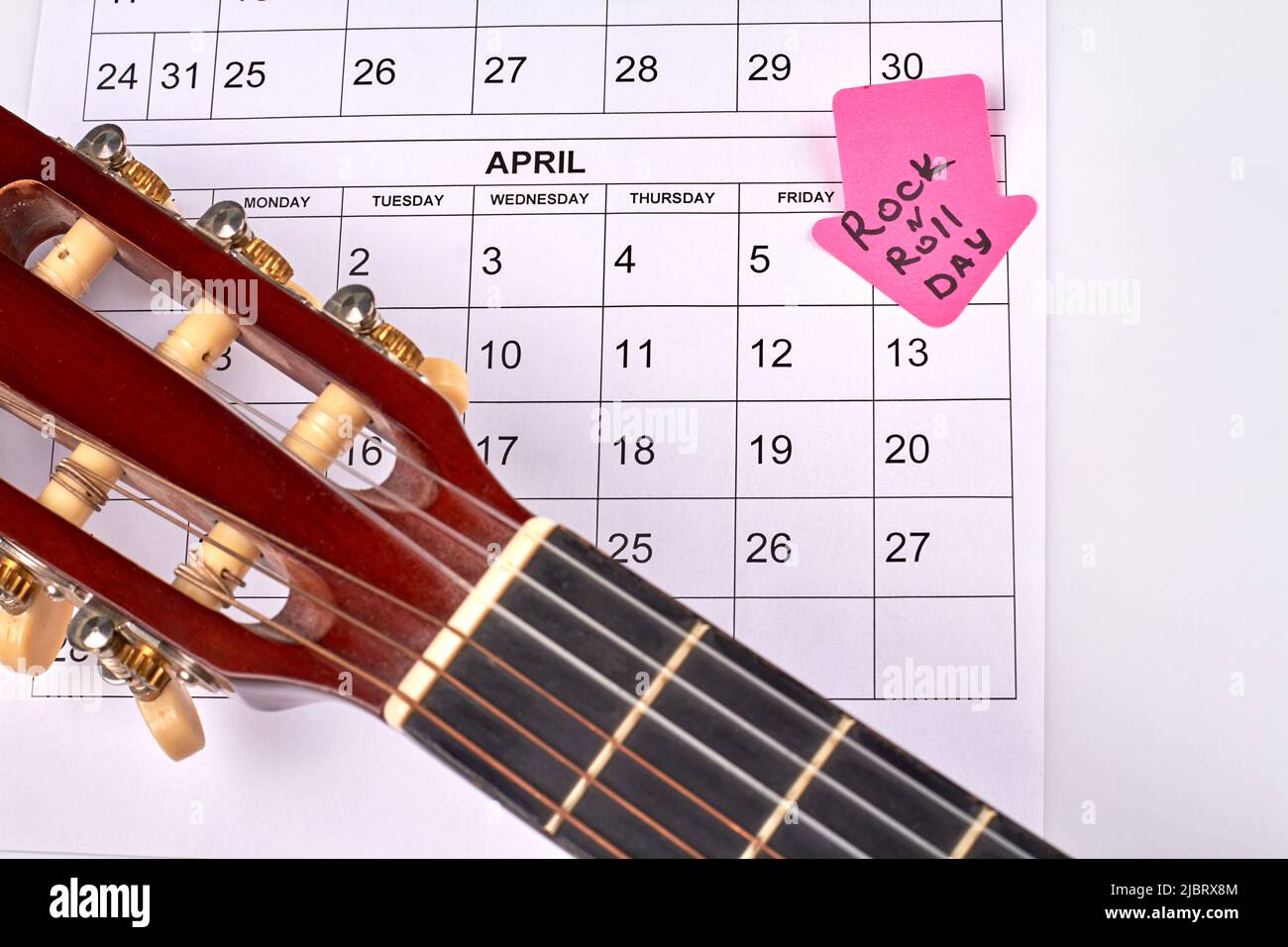 Closeup guitar on the calendar. Rock and roll day concept. Arrow with