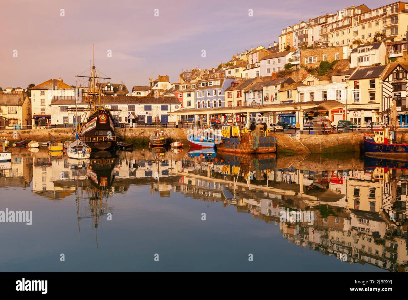 UK, England, Devon, Torbay, Brixham Harbour with The Quay and Golden Hind (Museum Ship) at Dawn Stock Photo