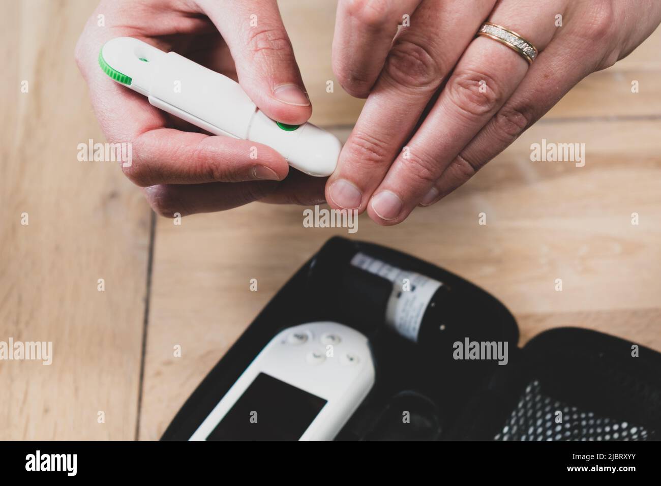 Woman pricking her finger to check blood glucose level with
