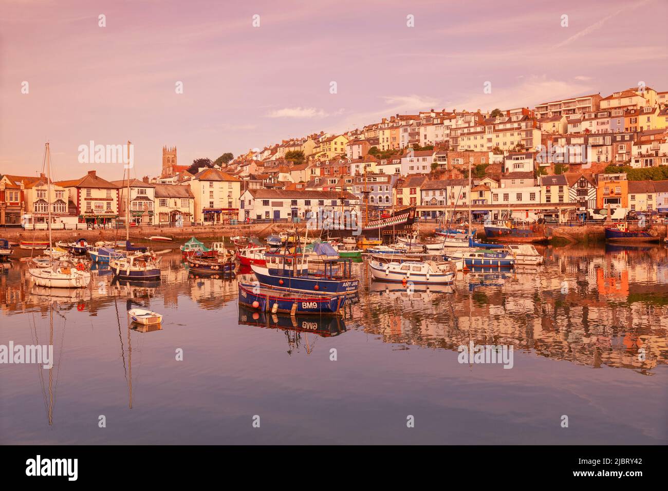 UK, England, Devon, Torbay, Brixham Harbour with The Strand and the Golden Hind (Museum Ship) at Dawn Stock Photo