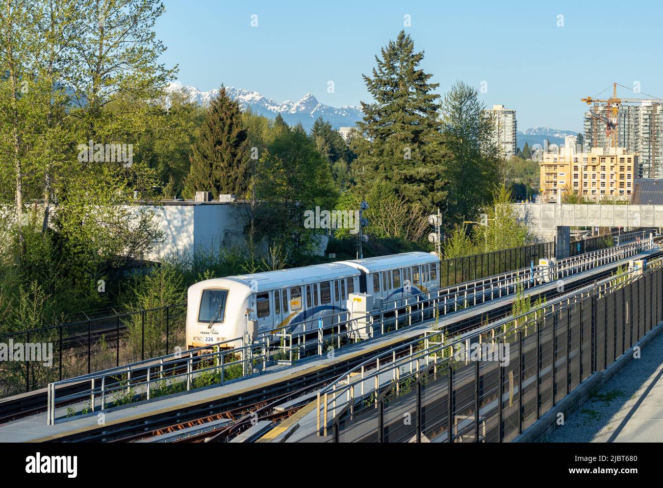 Millennium Line SkyTrain. Moody Centre station. City skyline and nature landscape in the background. Urban transportation concept. Stock Photo