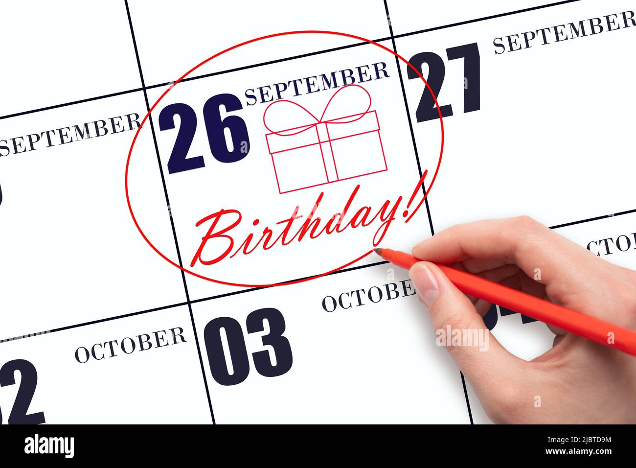 26th day of September. The hand circles the date on the calendar 26 September , draws a gift box and writes the text Birthday. Holiday. Autumn month, Stock Photo