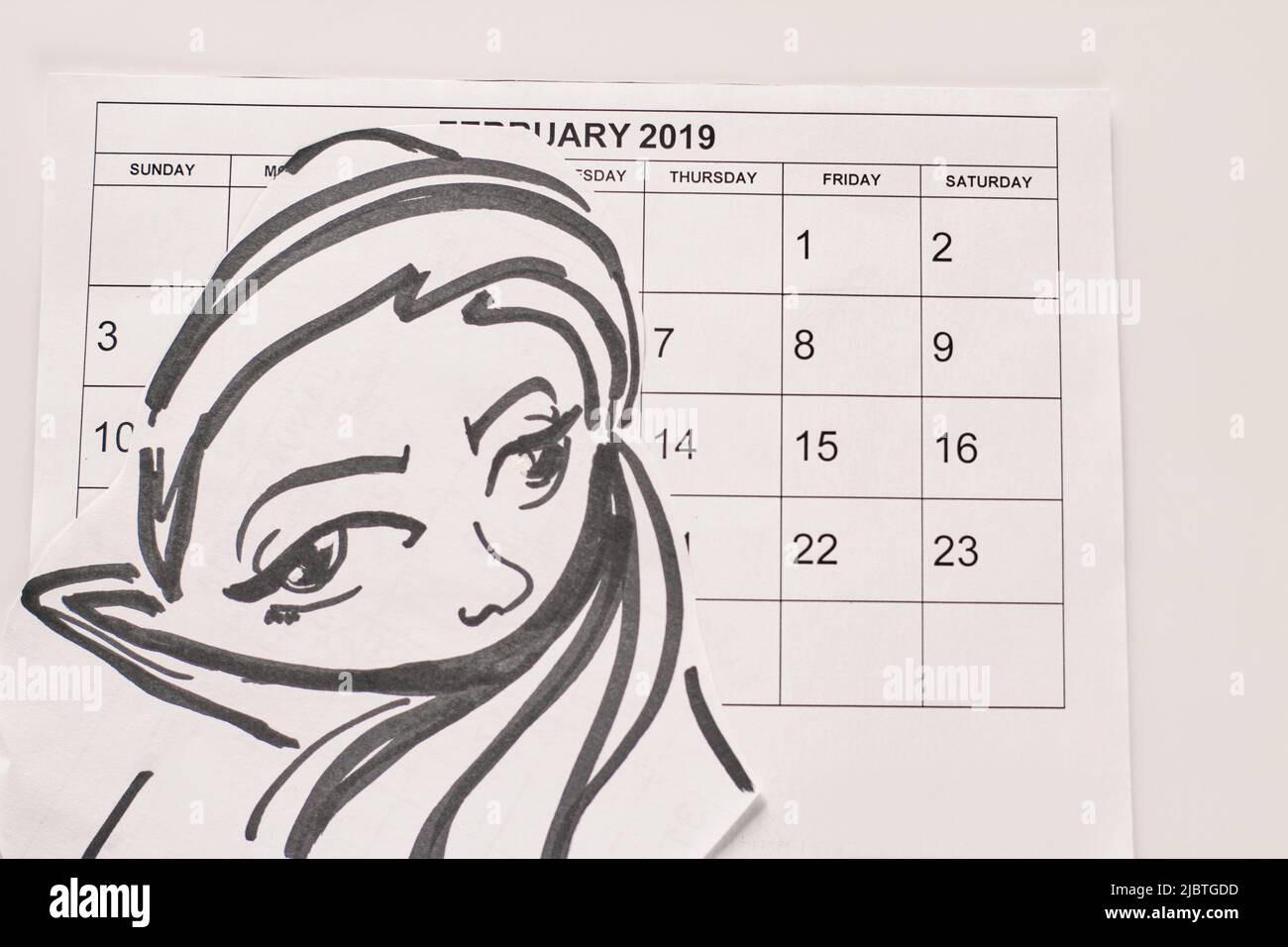 Paper month calendar and drawn womans face in hijab. 1 february hijab day concept. Stock Photo