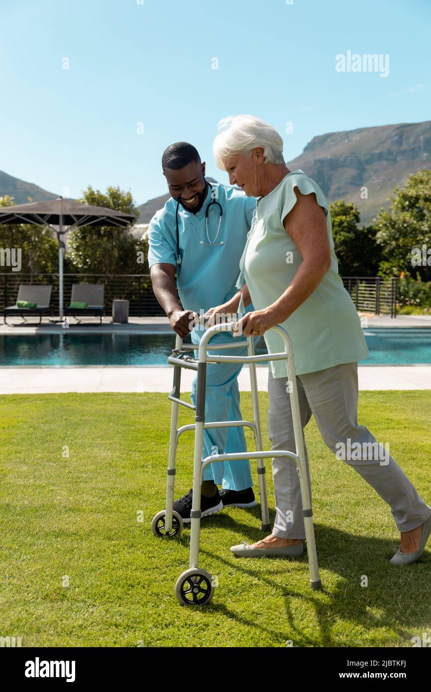 African american male health worker helping caucasian senior woman to