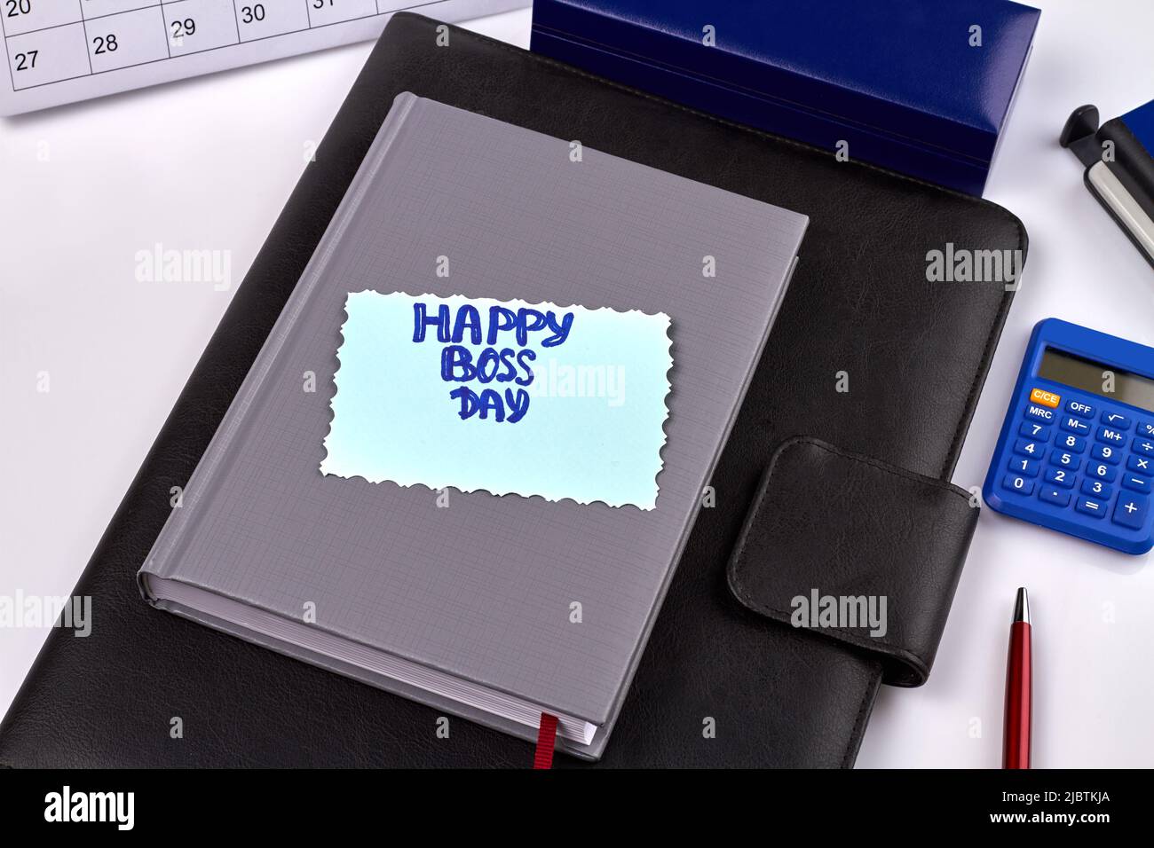 Happy boss day greeting. Notebooks with calculator and pen. Top view office stuff on white background. Stock Photo