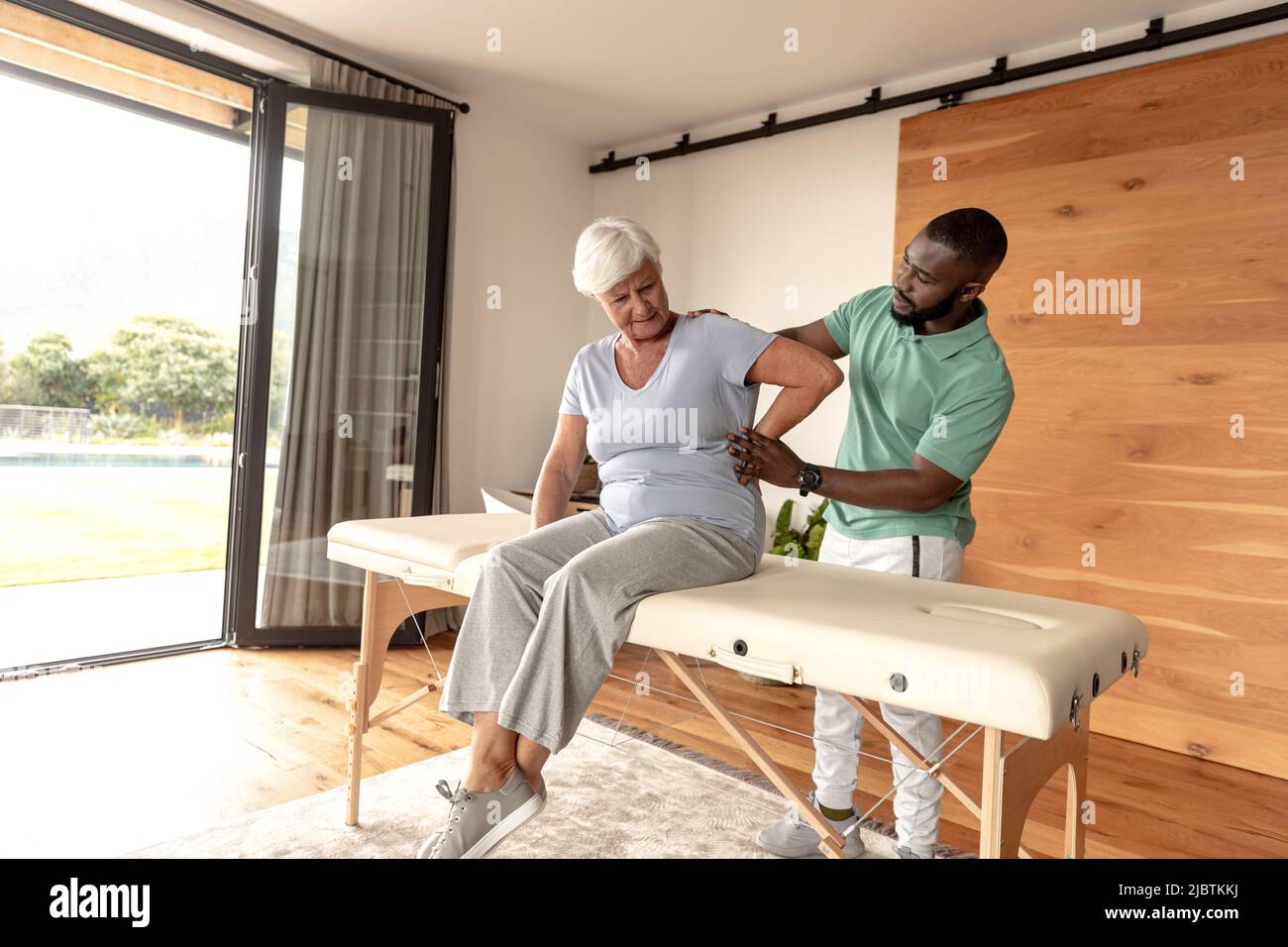 African american male physiotherapist giving back massage therapy to