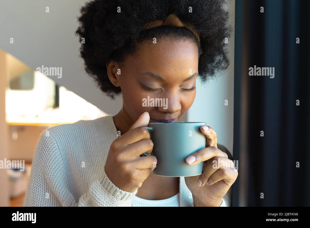 Close up of african american young woman drinking coffee at home Stock Photo