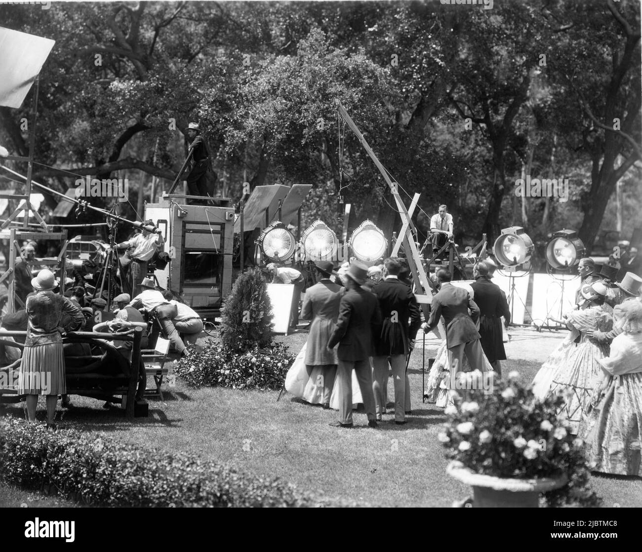 Movie Crew and Extras on set location candid including Cameraman in Sound Proof Box during