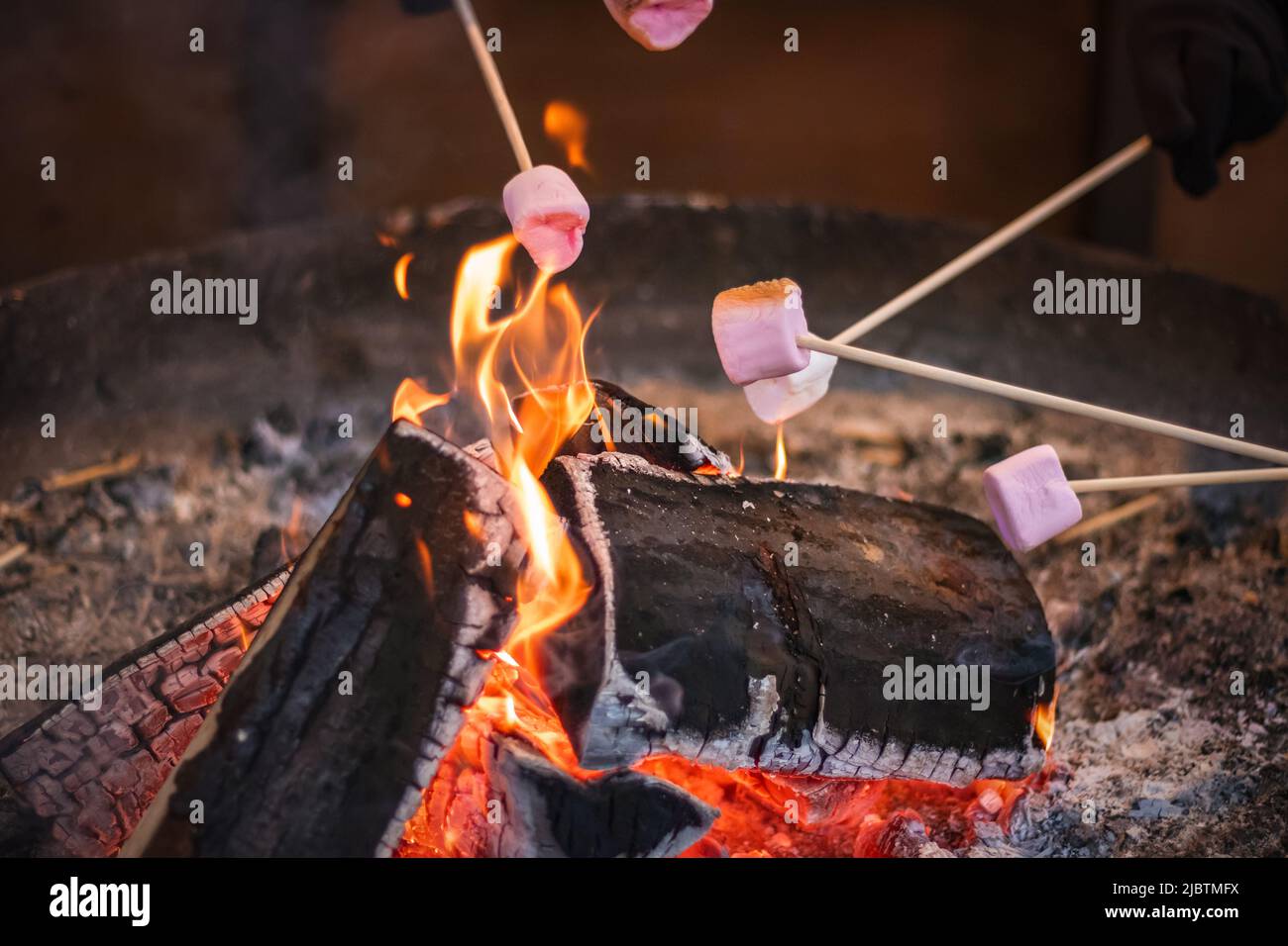Toasting a marshmallow over an open flame at Christmas market Hyde Park Winter Wonderland in London Stock Photo