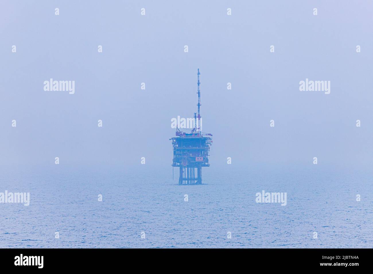A misty view of an oil or gas platform in the North Sea halfway between Essex and The Netherlands Stock Photo