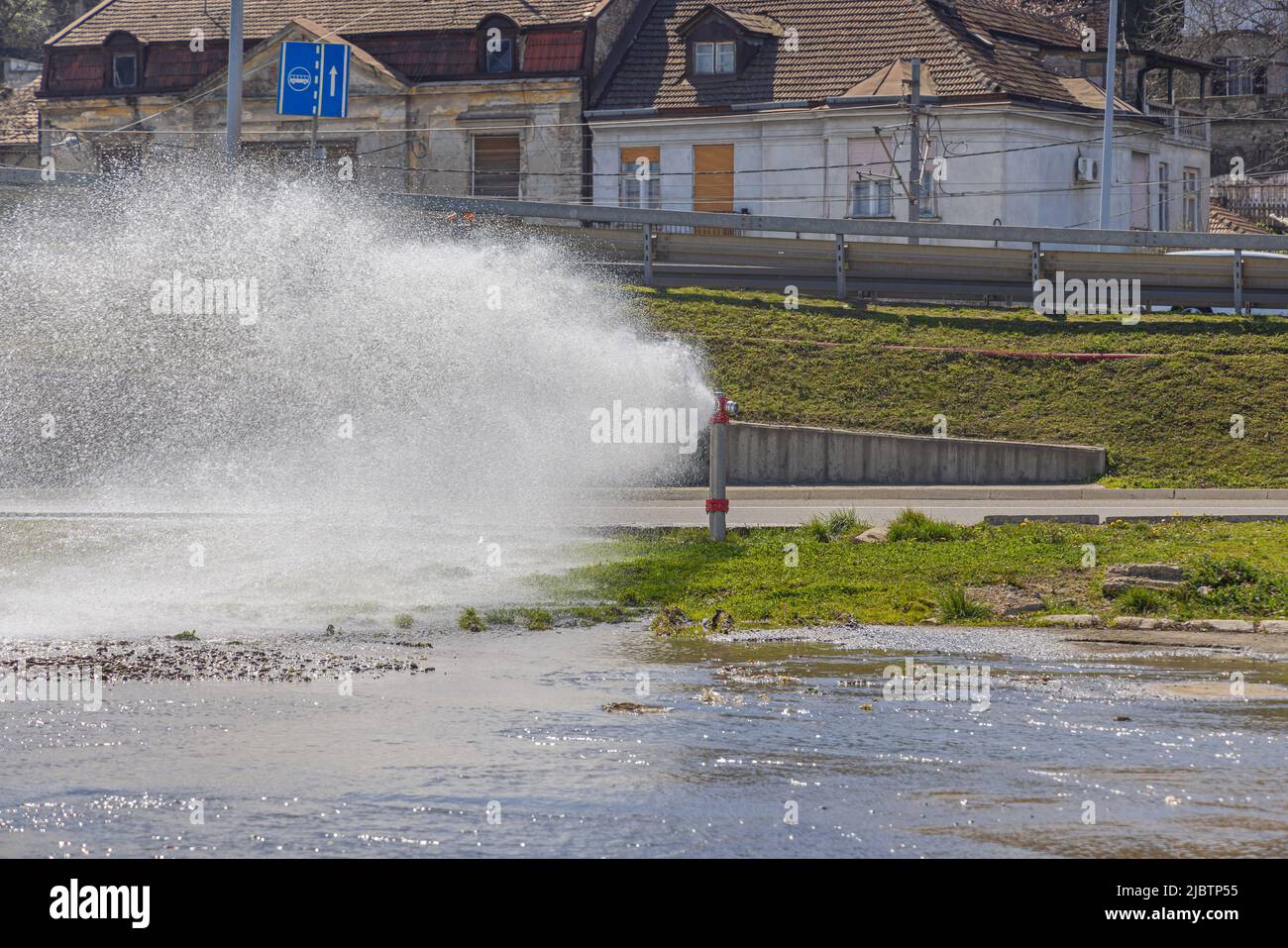 Broken Fire Hydrant Spraying Water at Street and Park Floods Stock