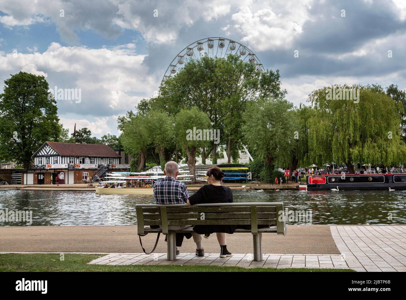 A couple sitting on a bench talking in a relaxed picturesque setting. Relationship, marriage, love or support concept. Stock Photo