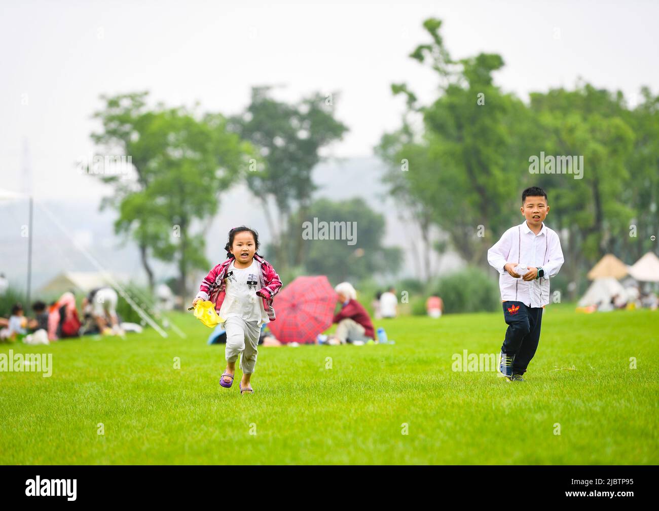Chongqing. 5th June, 2022. Children have fun in Guangyang Isle in southwest China's Chongqing, June 5, 2022. Guangyang Isle, the largest island on the upper Yangtze River, is rich in natural resources. In recent years, a series of measures have been taken to restore the island's ecological environment, attracting tourists to its colorful fields. Credit: Wang Quanchao/Xinhua/Alamy Live News Stock Photo