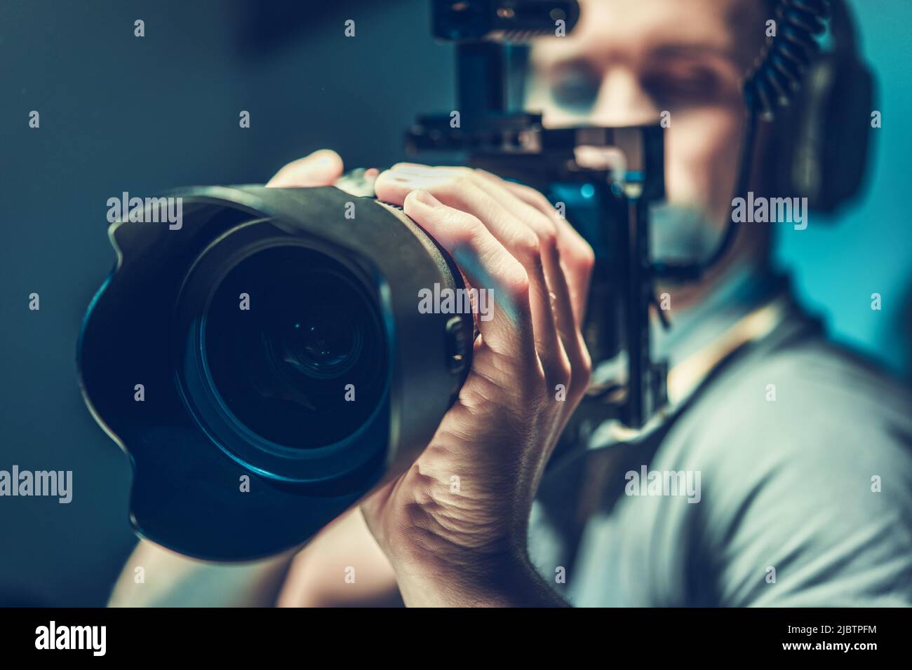 Male Videographer Focused and Concentrated on Recording the Footage with His Mirrorless Camera. Digital Videography Industry Theme. Stock Photo