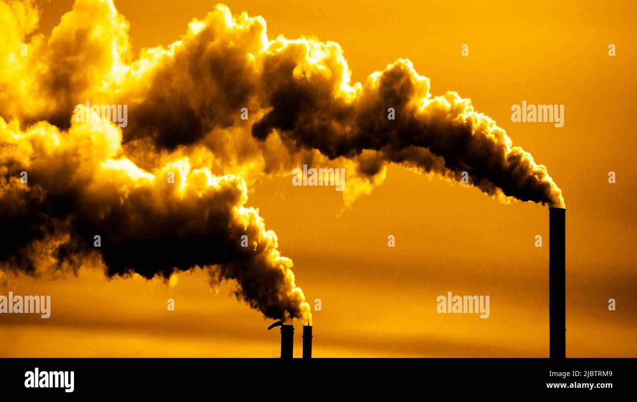 Pollution and smoke from chimneys of factory or power plant belching into atmosphere panorama Stock Photo