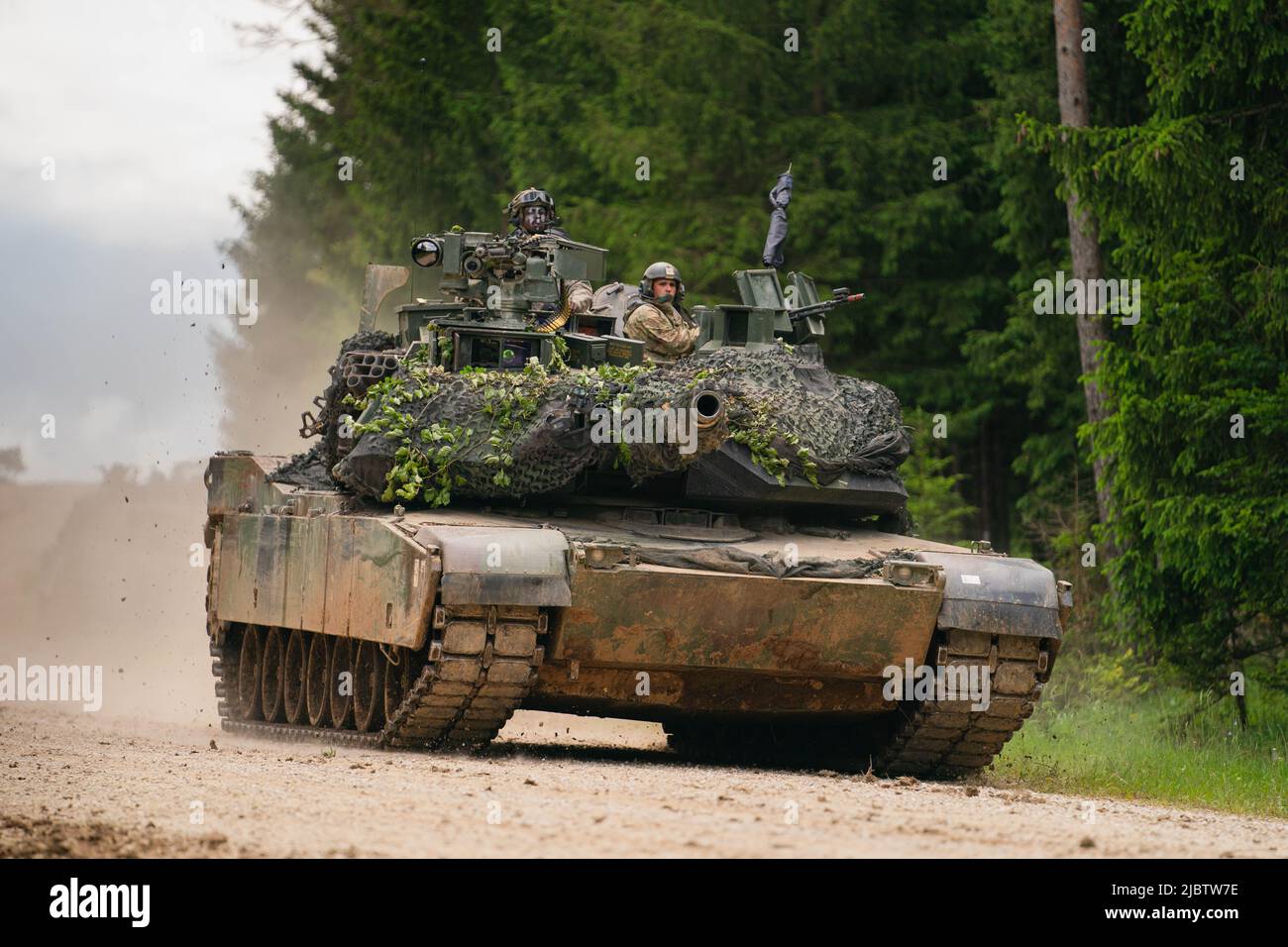 Hohenfels, Germany. 08th June, 2022. A US Army M1 Abrams tank drives across a road during a multinational exercise at the Hohenfels training area. Credit: Nicolas Armer/dpa/Alamy Live News Stock Photo