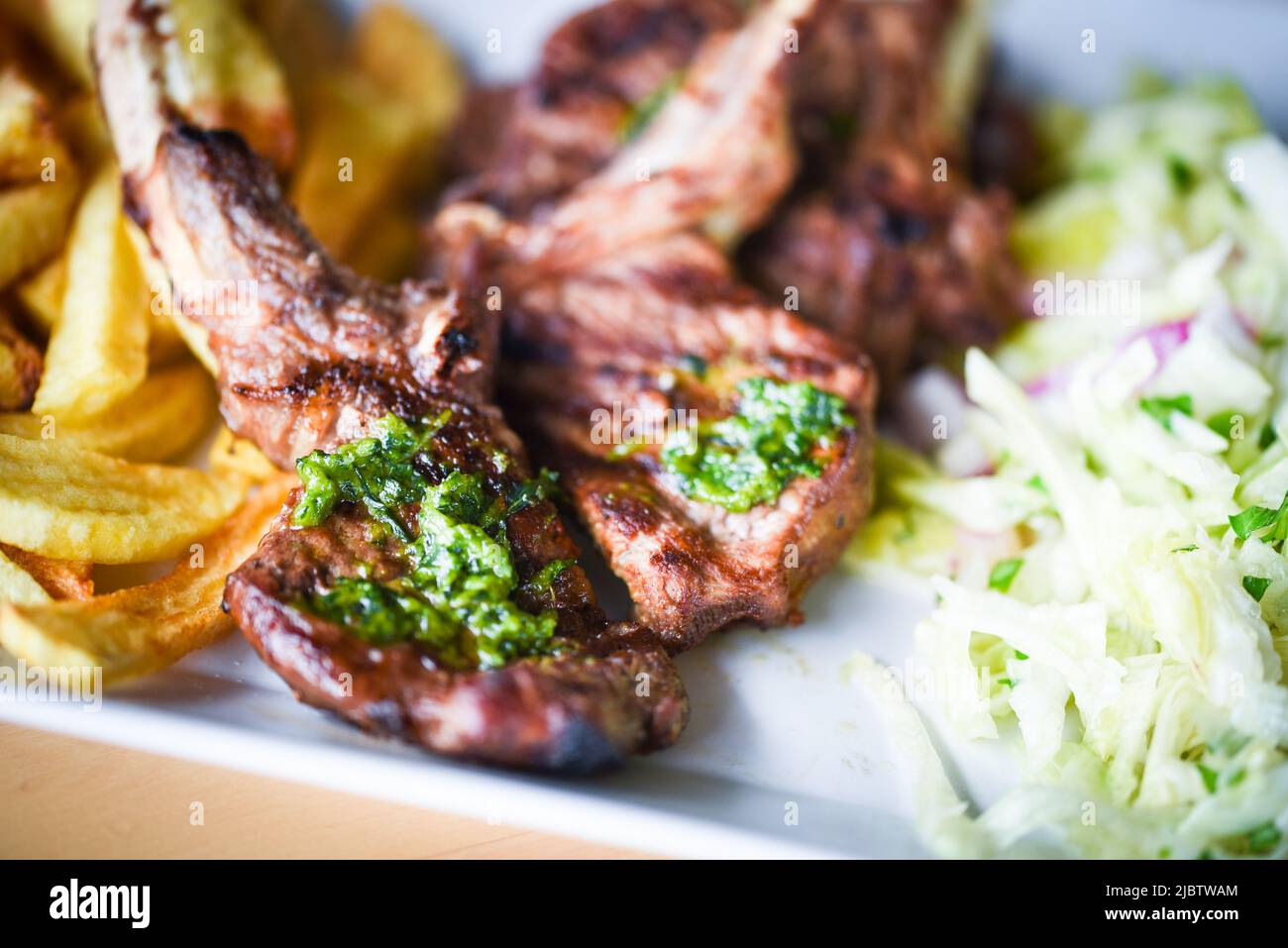 delicious grilled lamb chopsticks with french fries, pesto sauce & mix