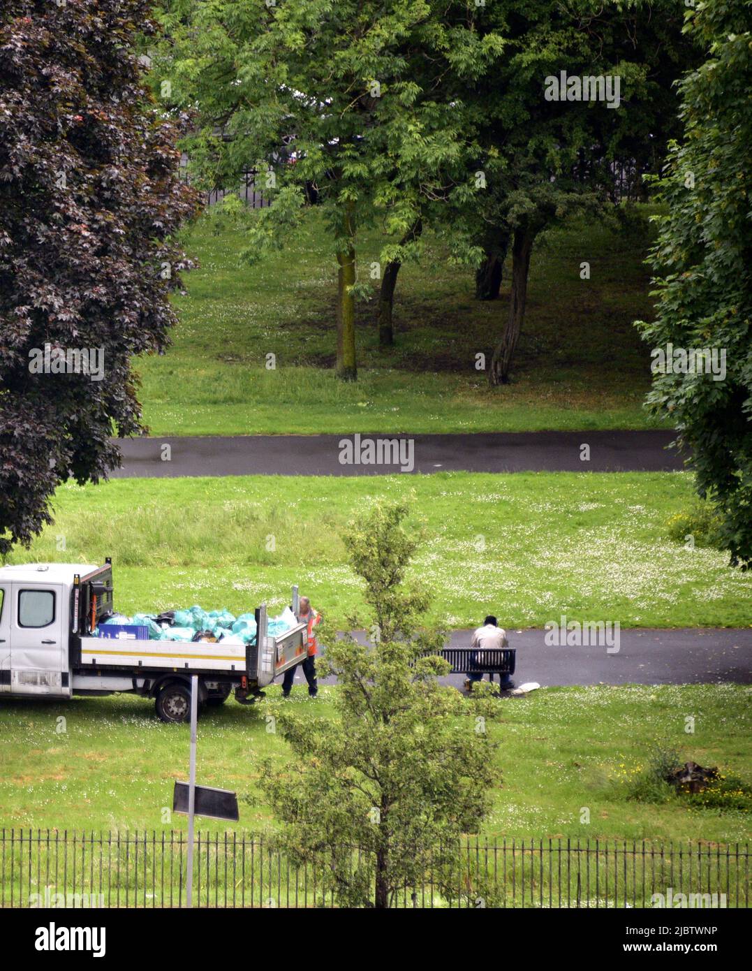 Manchester, UK, 8th June, 2022. Overhead view. A refuse collection worker collects rubbish in Ardwick Green Park, owned by Manchester City Council, England, United Kingdom, British Isles. Delivery of services by local government. The three local government unions, Unite, UNISON, and GMB, have submitted a pay claim for staff in England, Wales and Northern Ireland to receive a pay  increase of £2,000 each or the current rate of RPI (presently 11.1%), whichever is higher for each individual. Credit: Terry Waller/Alamy Live News Stock Photo