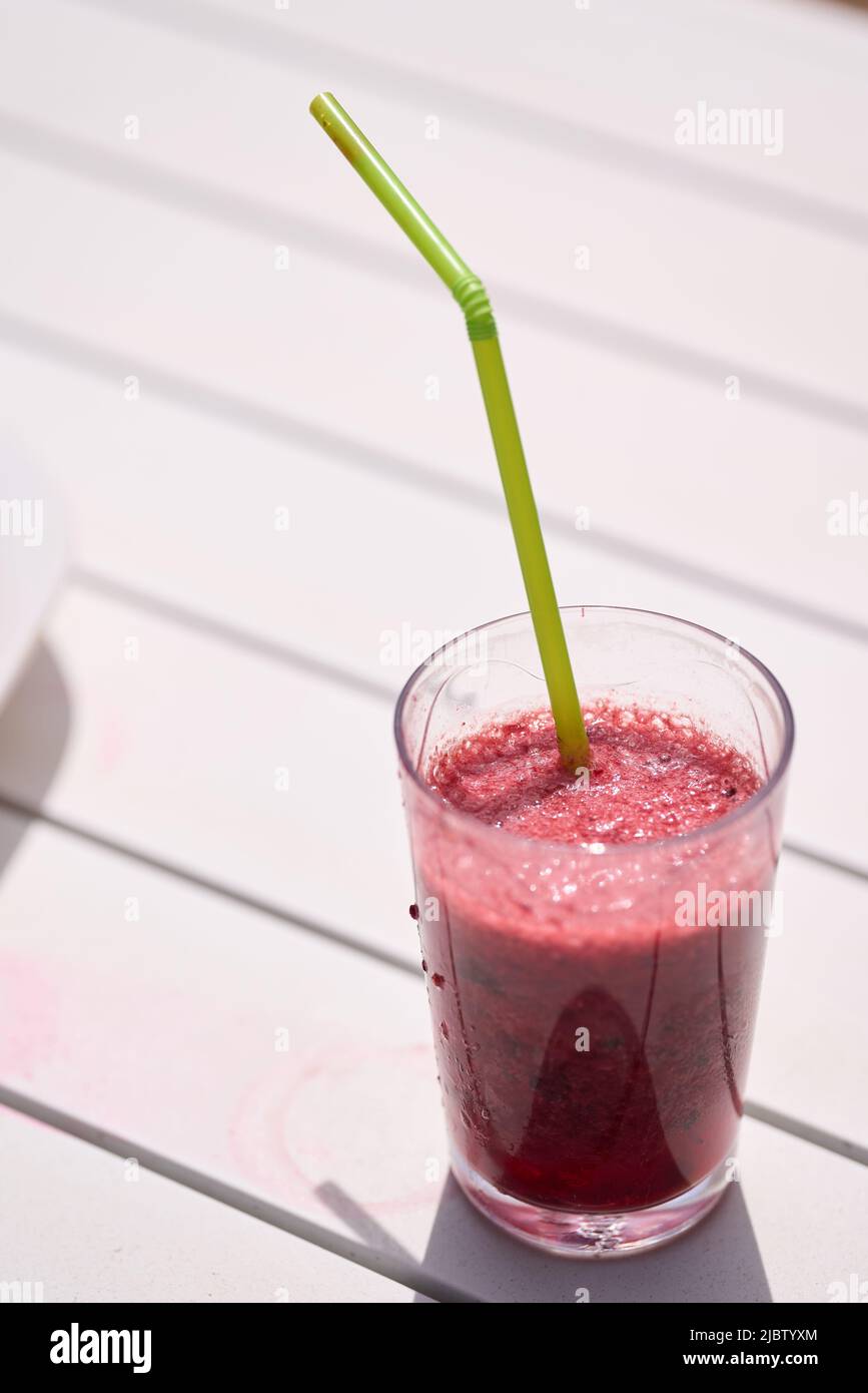 Glass with natural smoothie of red fruits, strawberry and blueberries Stock Photo