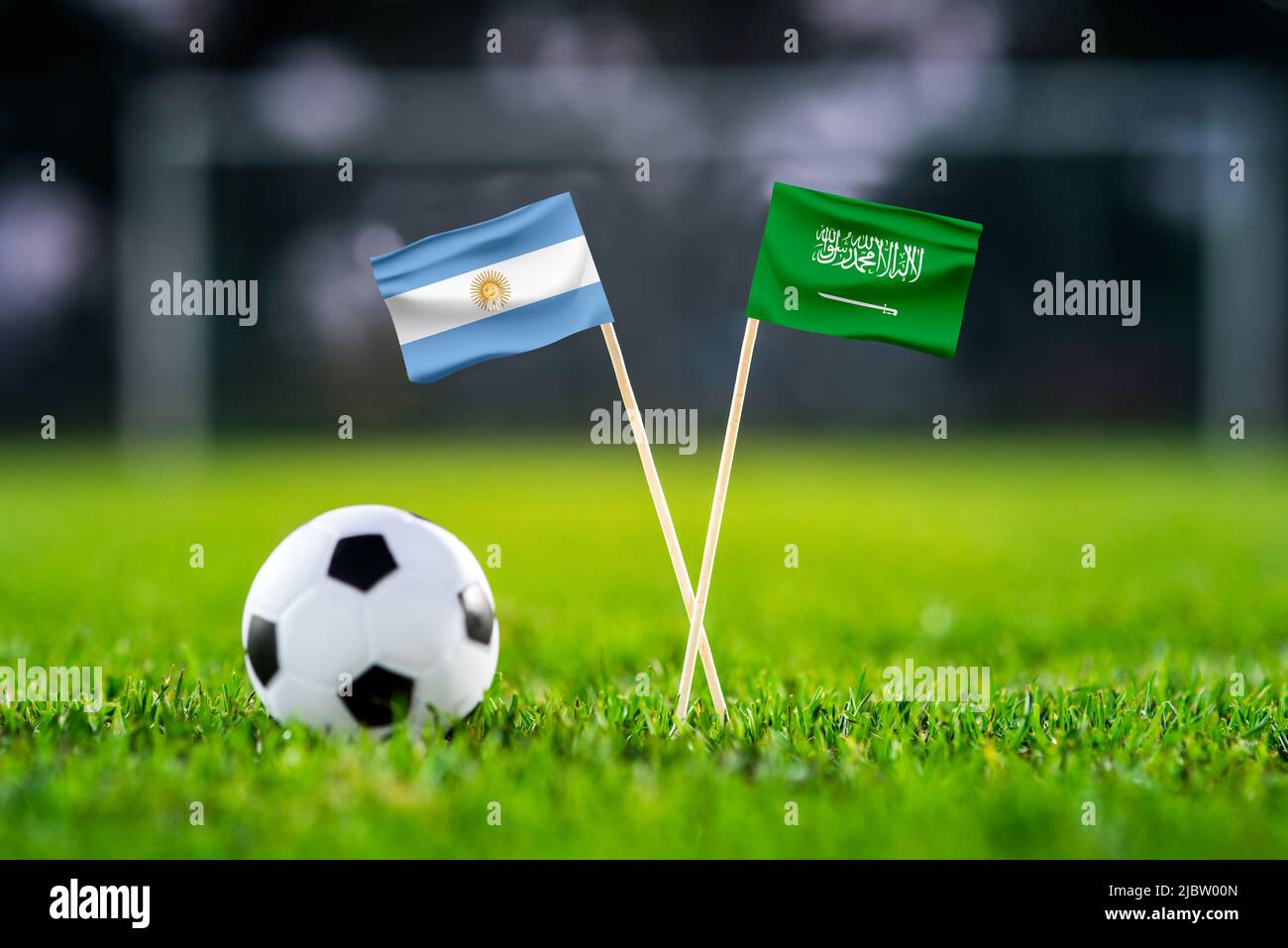 Argentina vs. Saudi Arabia, Lusail,, Football match wallpaper, Handmade national flags and soccer ball on green grass. Football stadium in background. Stock Photo