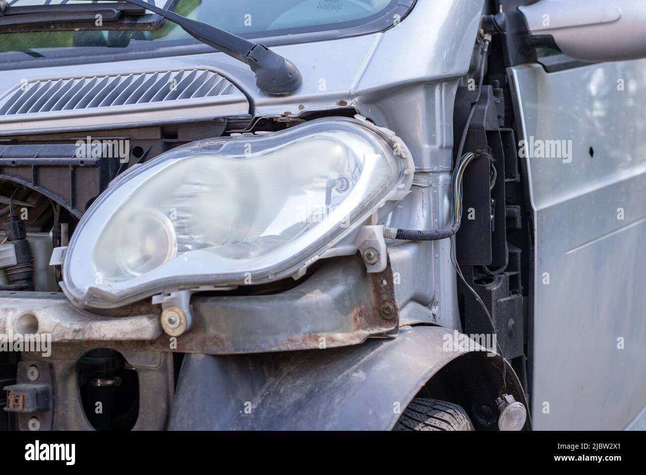 Broken headlights as a result of a collision. Broken gray car after an