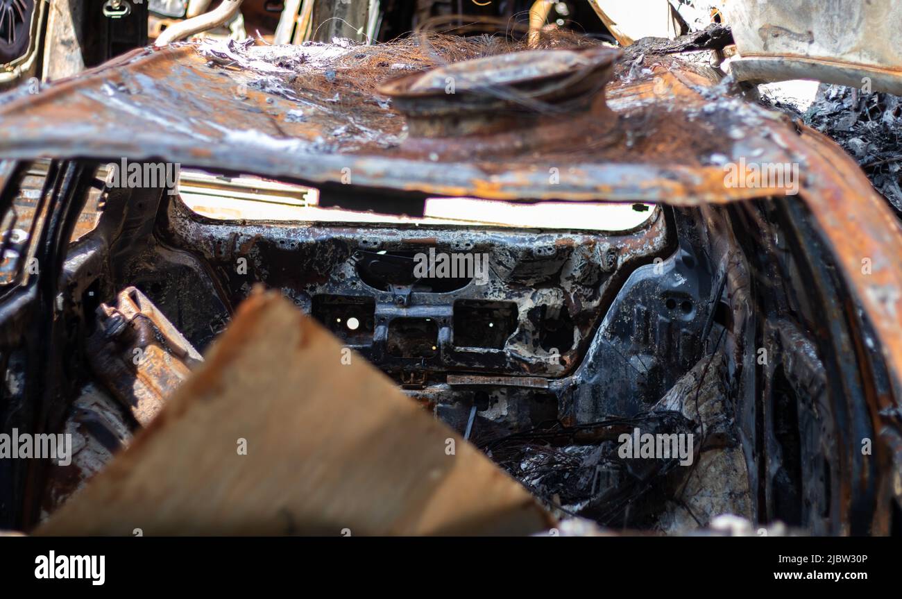 Broken and burned cars in the parking lot, accident or deliberate vandalism. Burnt car. Consequences of a car accident. Damaged by arson. Dump of civi Stock Photo