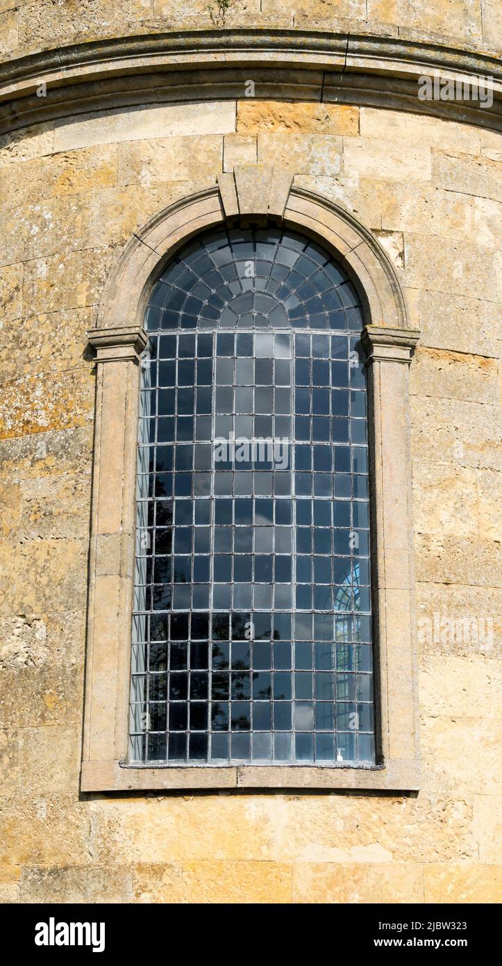 Large arched leaded light church window in circular wall Stock Photo
