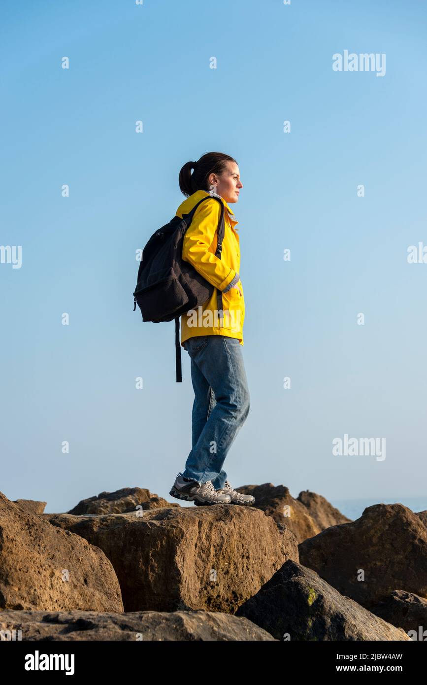 woman looking out to sea, hiker with backpack. Stock Photo