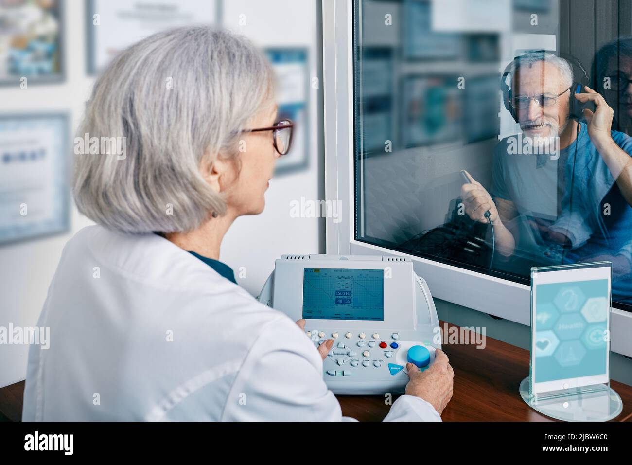 Senior man getting hearing test at audiology center. Audiometry, hearing check-up Stock Photo