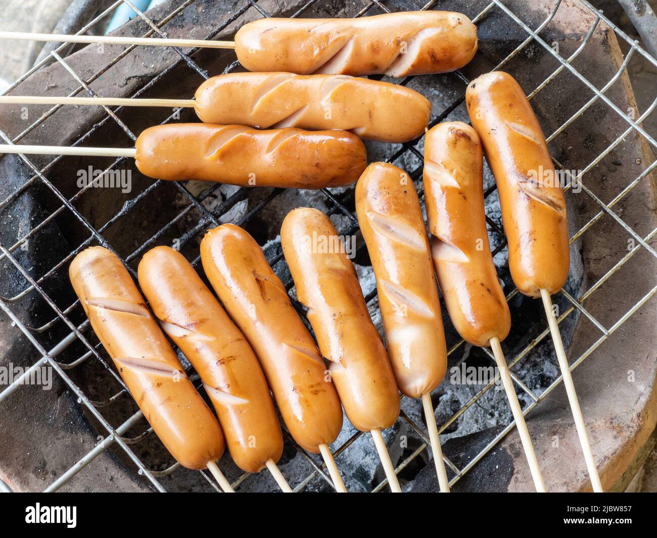 https://c8.alamy.com/comp/2JBW857/the-pork-sausage-skewers-are-grilled-on-a-metal-grill-on-the-stovetop-outside-the-local-house-top-view-with-the-copy-space-2JBW857.jpg