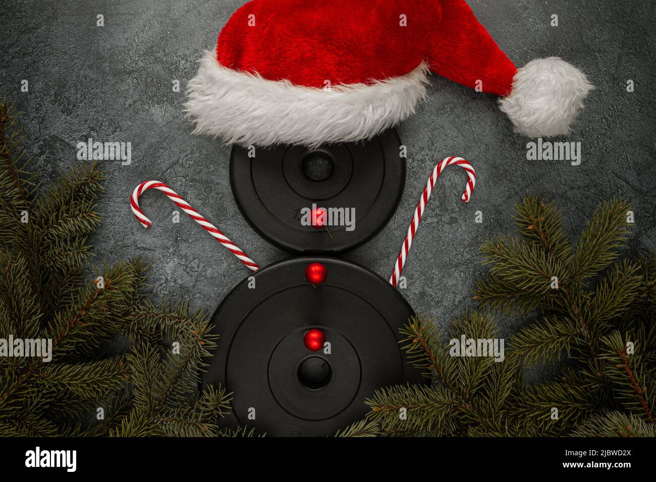 Dumbbells weight plates as snowman with red Santa Claus hat, candy