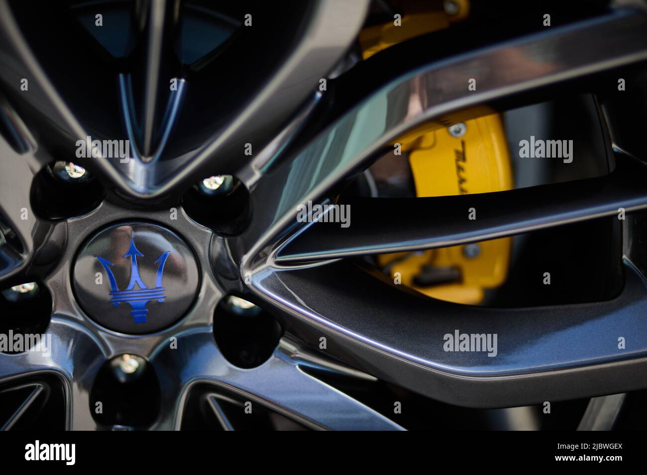 New black Maserati aluminium wheel, closeup on the logo and yello