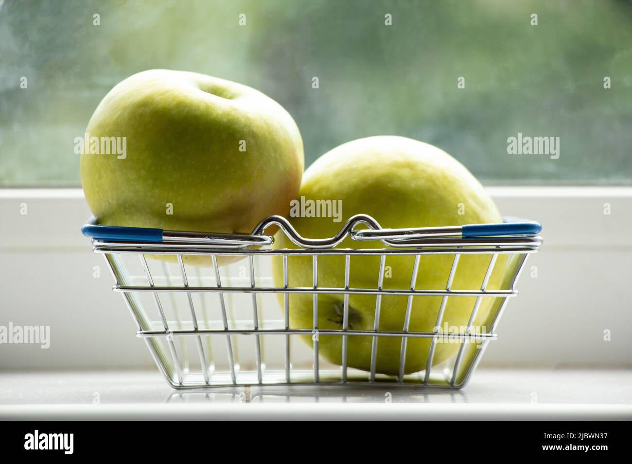 Two Riped Apple Two ripe green apples lie in a basket from the supermarket on the ...