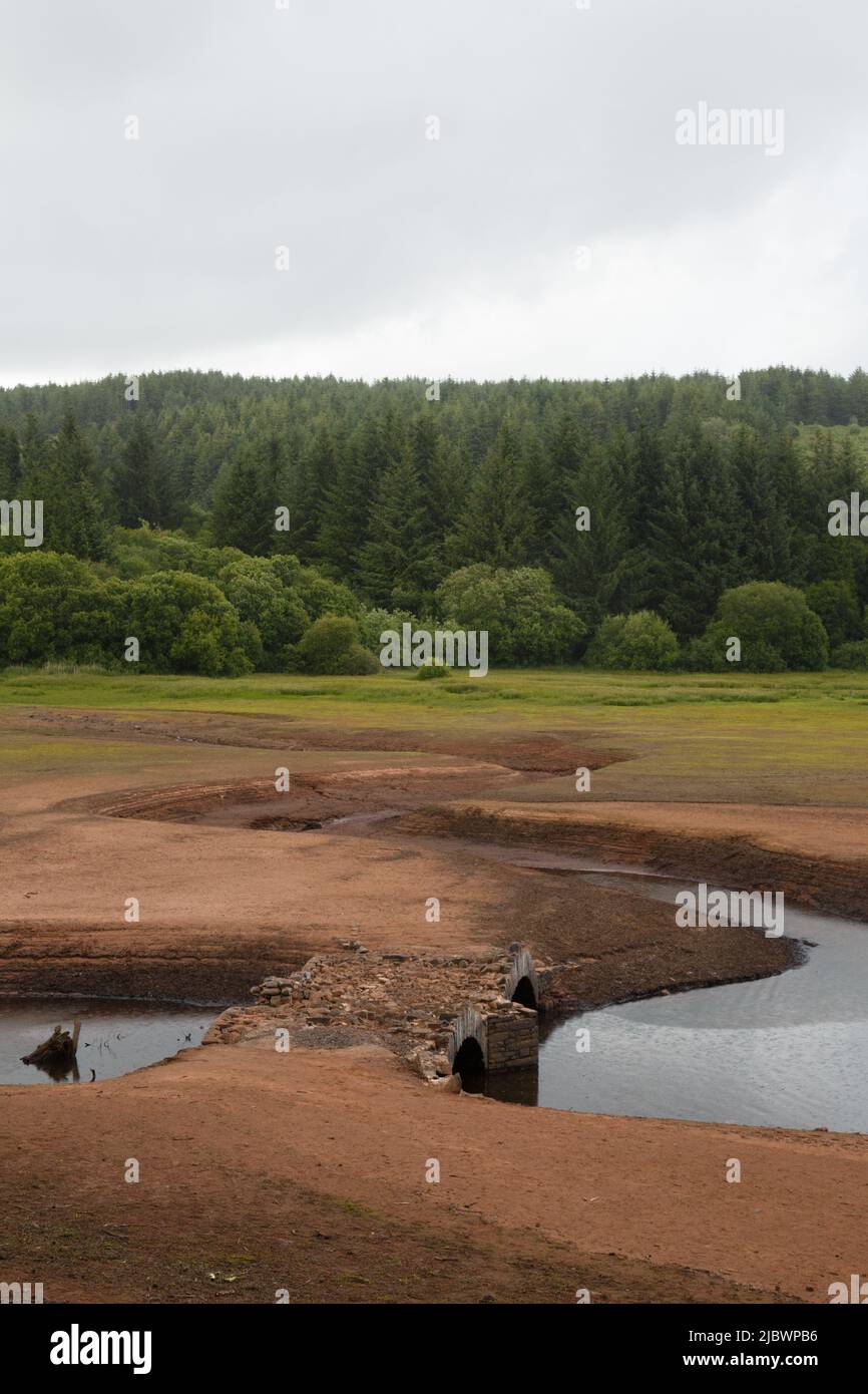 Llwyn Onn Reservoir, South Wales. UK.  8 June 2022.  UK weather:  Lower water levels than normal this afternoon, with parts of the reservoir drying up.  An old bridge has been uncovered, which was in use before the reservoir was constructed, Pont Yr Daf.  Credit: Andrew Bartlett/Alamy Live News. Stock Photo
