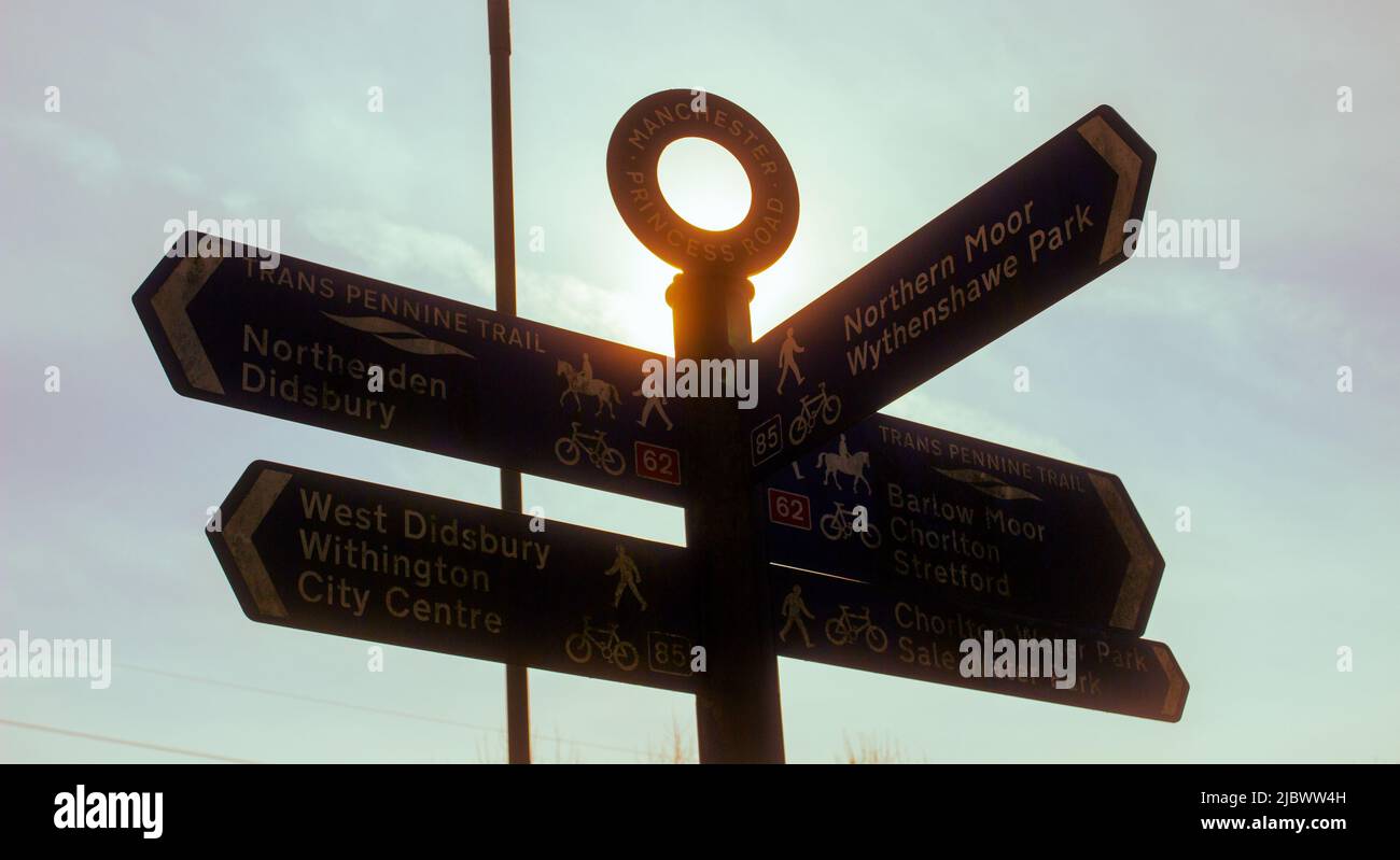 A sign post silhouetted against the sun. Stock Photo