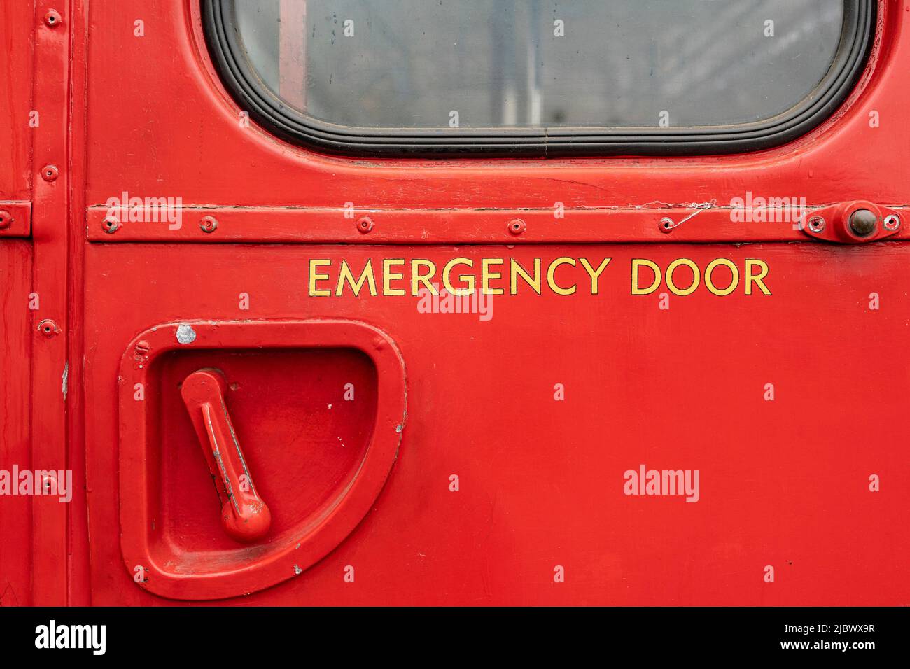 rear emergency door and handle on a red double decker bus Stock Photo
