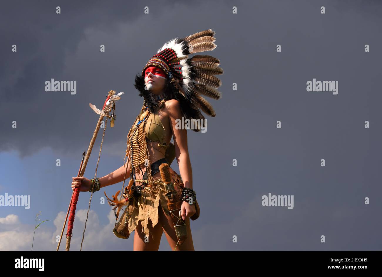 A native American Indian woman is seen standing in front of grey ...
