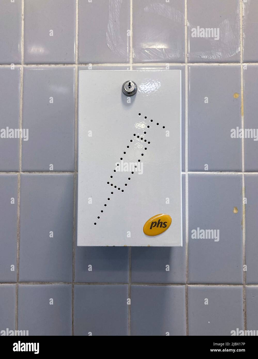 A disposal unit for syringes and needles on the wall of a public toilet