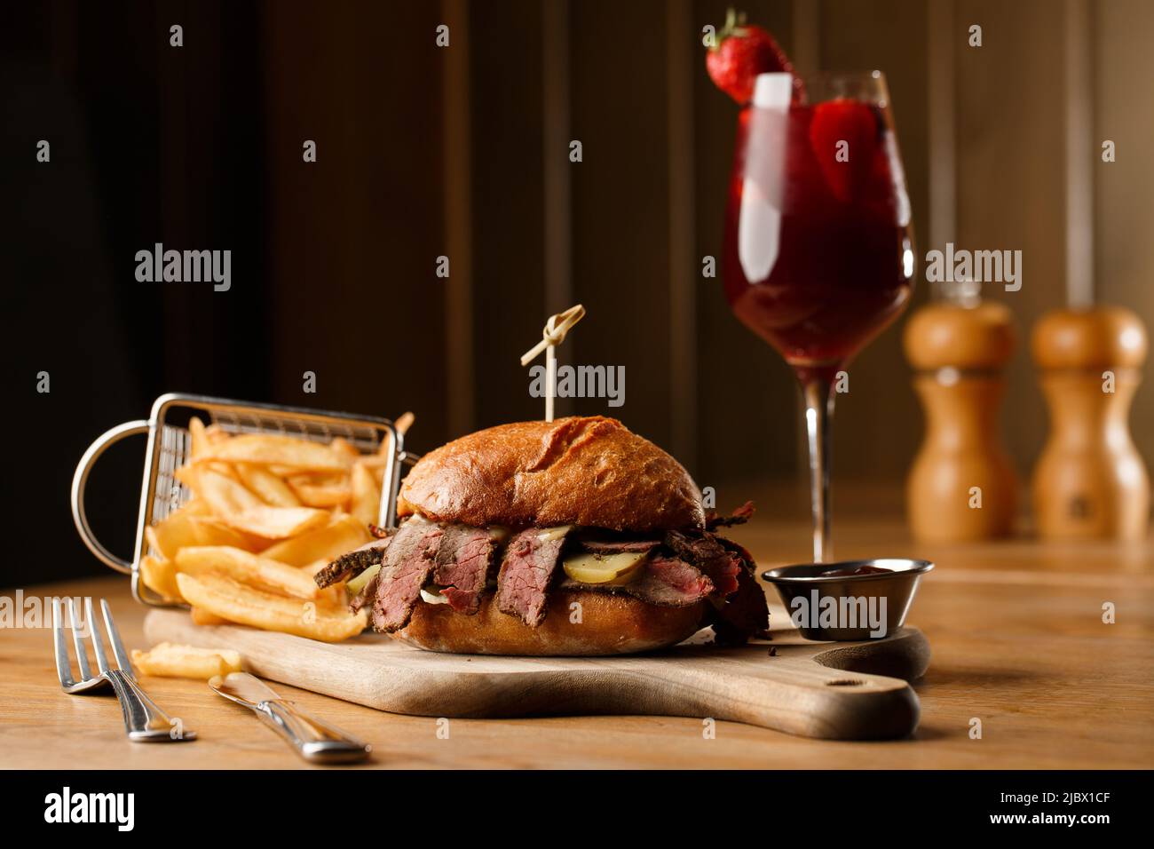 Pastrami sandwich on rye bread served with pickles and mustard sauce