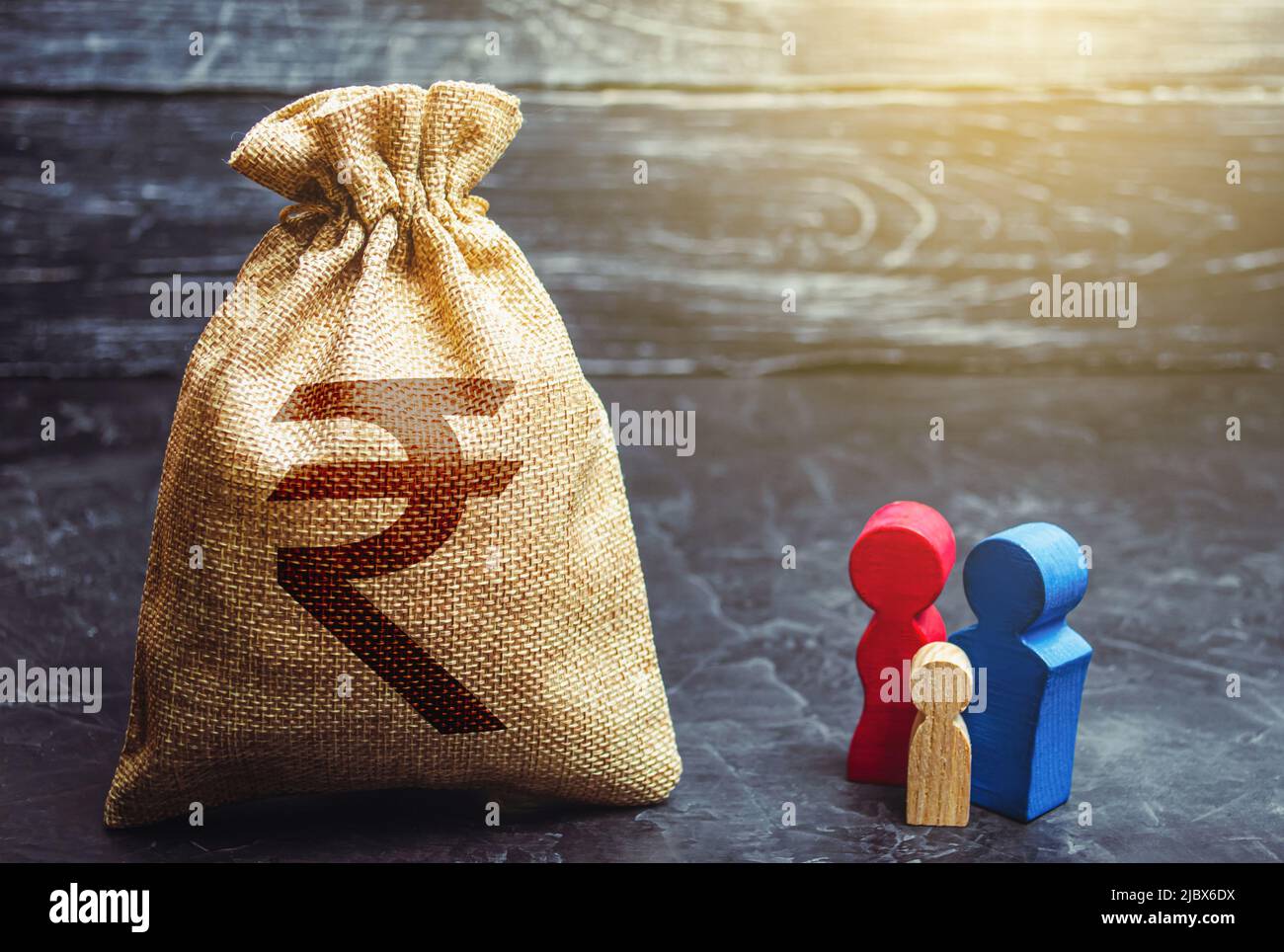 Family figurines and indian rupee money bag. Social assistance and