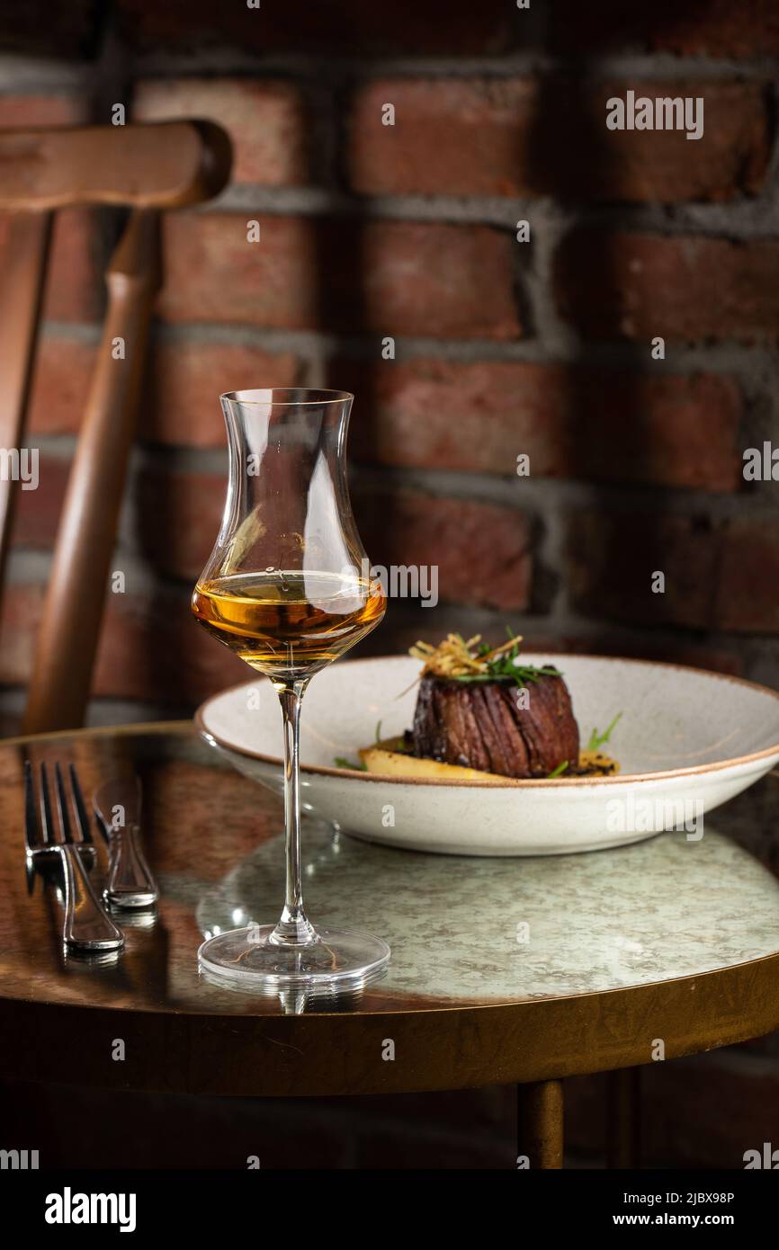 Grilled meat fillet steak medallion with green sauce, served with pear